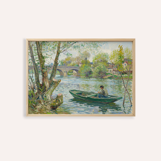 Framed print close-up of a man fishing in a green boat on a river with trees and a stone bridge
