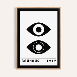 Bauhaus art print of stylized black eyes with minimalist typography in a light wood frame