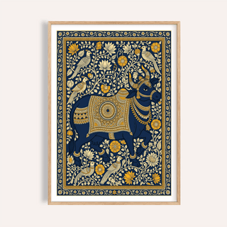 Framed Indian art print of a decorated blue cow with yellow and cream floral details