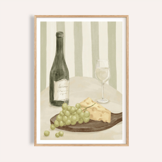 Framed print close-up of grapes, cheese and a bottle with glass in soft green tones