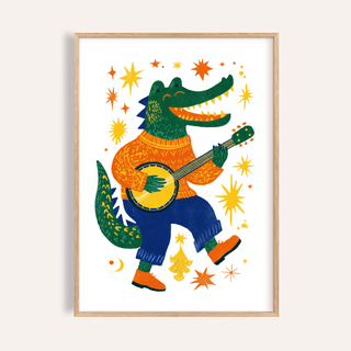 Framed close-up of funny crocodile art print with a green crocodile playing banjo wearing orange and blue