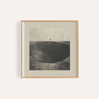 Framed Surrealist wall art of a figure standing by a dark abyss hole in muted greys