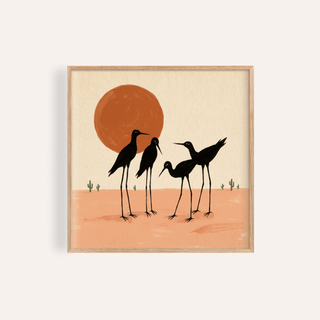 Framed Desert Birds wall art with black silhouetted shorebirds against an orange sun and peach sand
