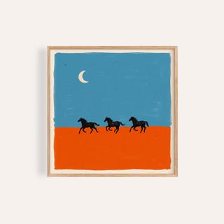 Framed horse silhouette wall art of three black horses running on an orange ground under a blue sky with a crescent moon
