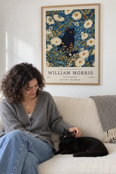Woman on the sofa with her black cat under the Night Garden print