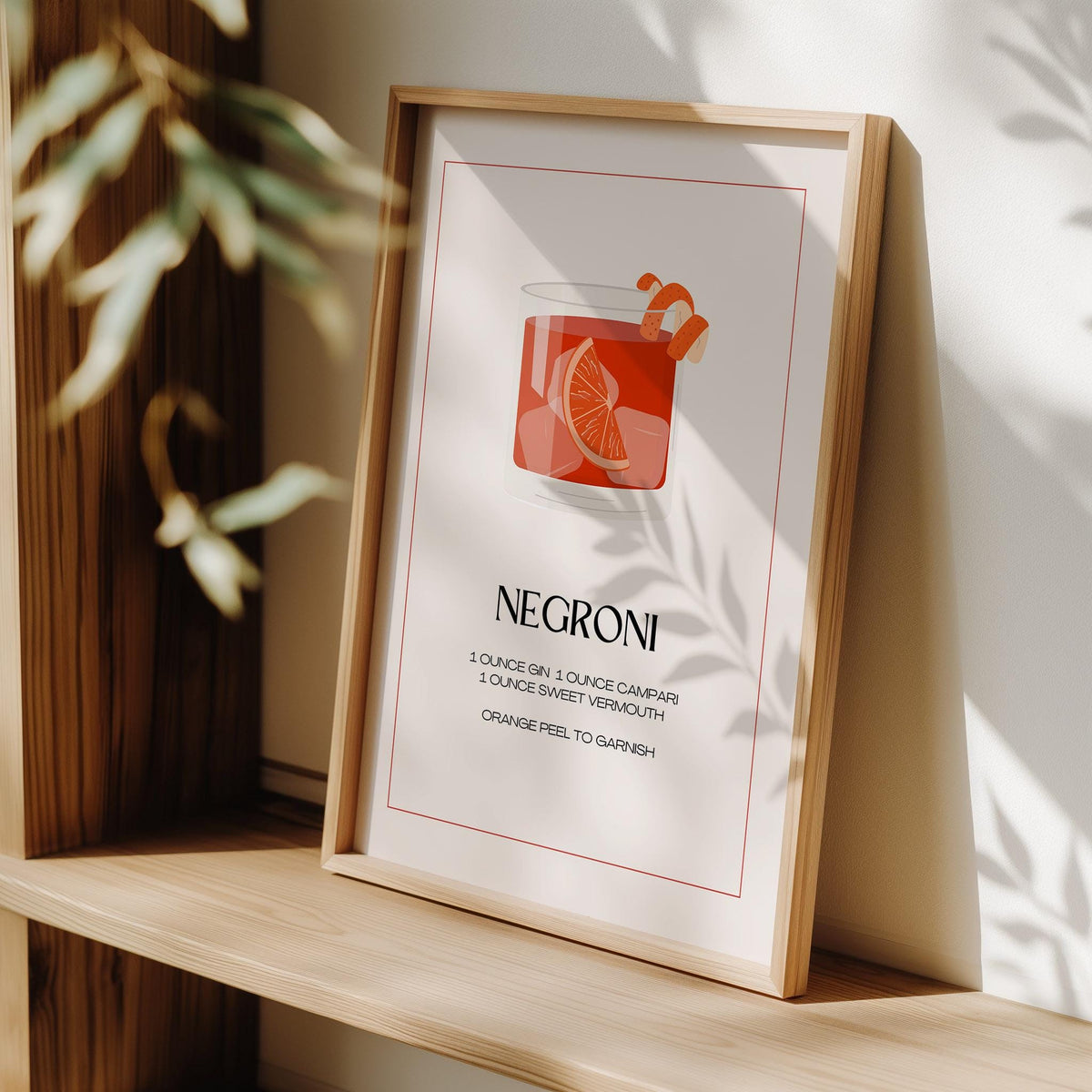 Framed print close-up of Negroni Cocktail Poster with minimalist red and orange illustration on a wooden shelf