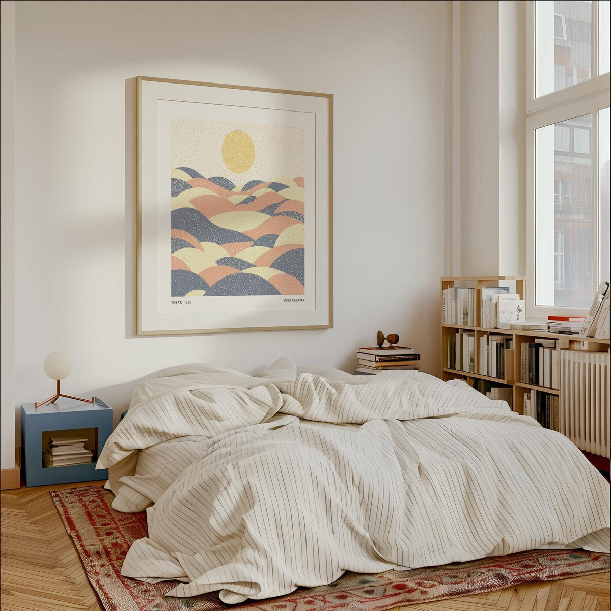 Pastel wall art of abstract hills with sun in soft yellow pink and blue above a bedside table lamp