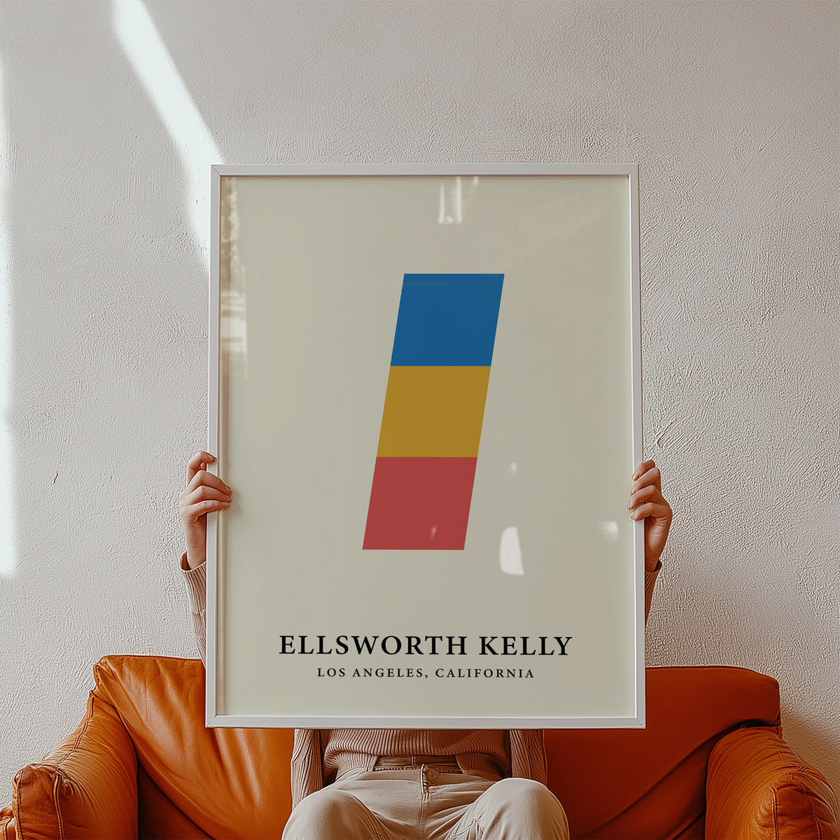 Framed Creative Wall Art print held above an orange sofa in a pale neutral room