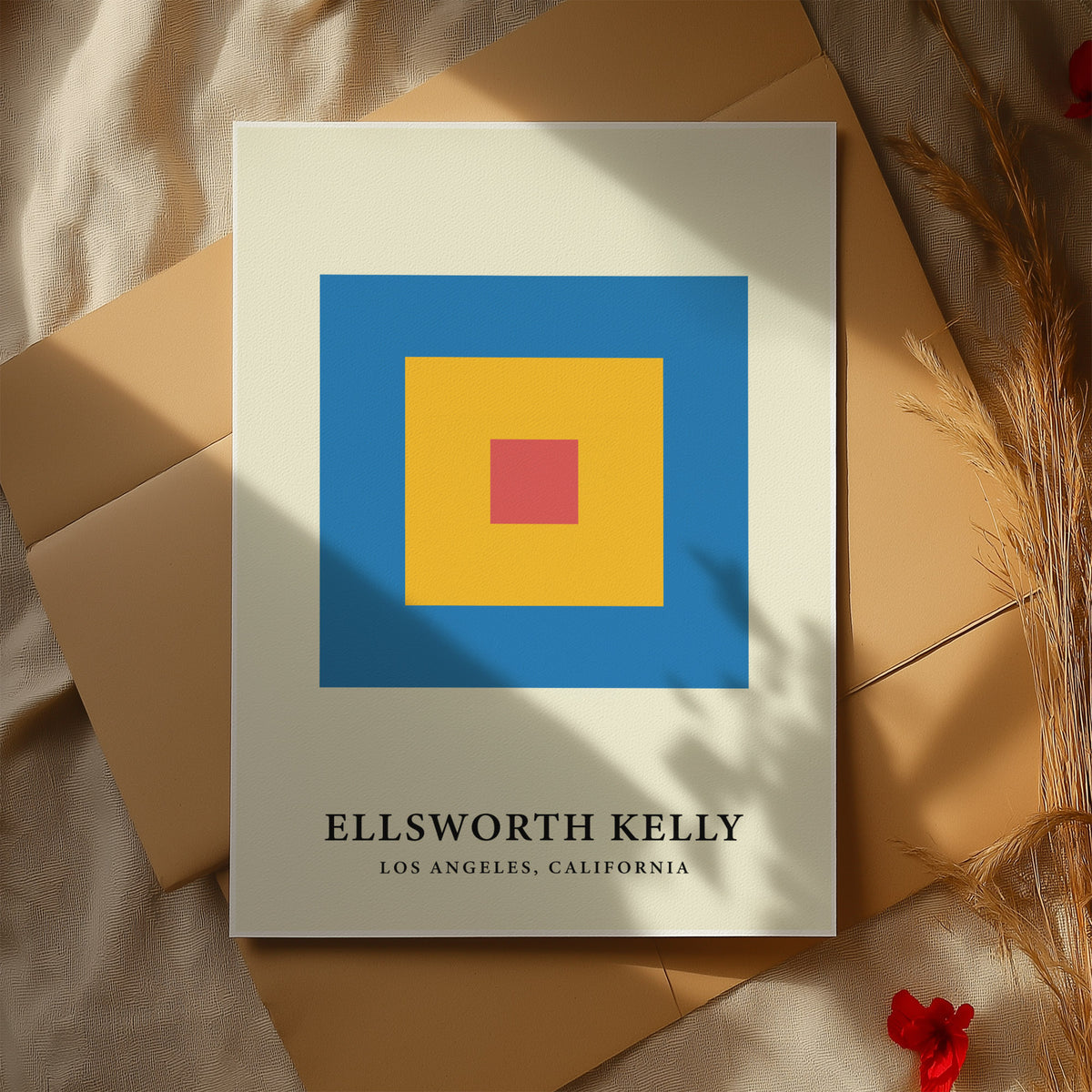 Minimalist Art print with concentric red yellow and blue blocks laid on cardboard with plant stems beside
