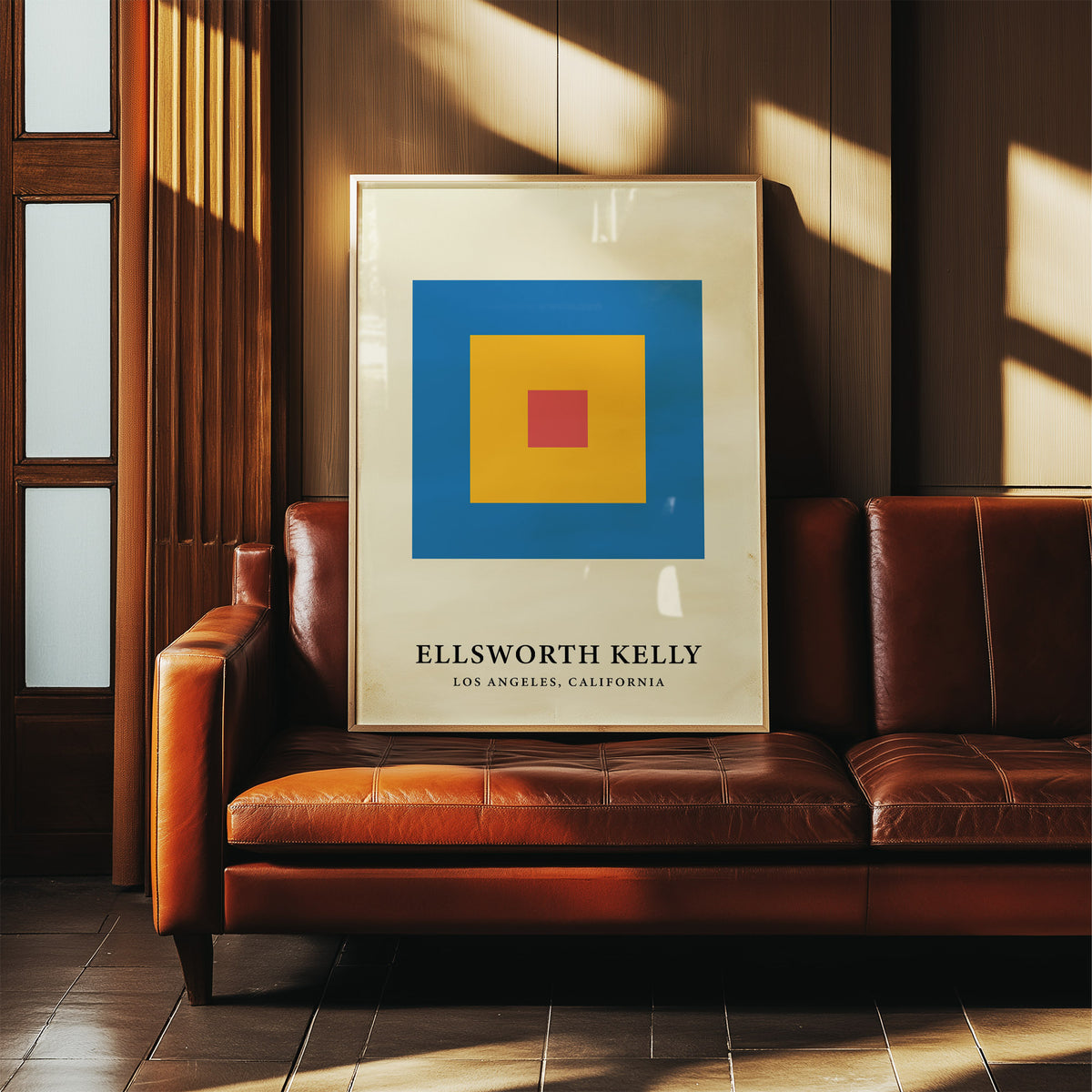 Minimalist Art print with red yellow and blue concentric blocks leaning on a brown leather sofa