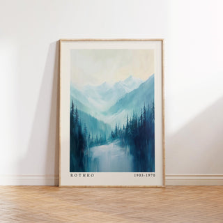 Framed nature print of pine trees with blue and green tones leaning on a wooden floor