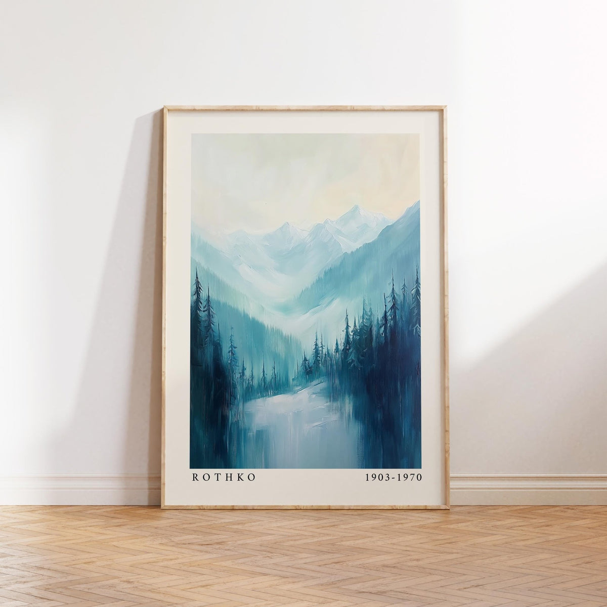 Framed nature print of pine trees with blue and green tones leaning on a wooden floor