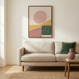 Modern Abstract Print above a beige sofa with a green cushion and pink vase in a bright living room