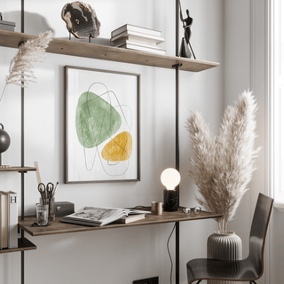 Abstract Watercolor Art hanging above a wooden desk with books and lamp in a bright room