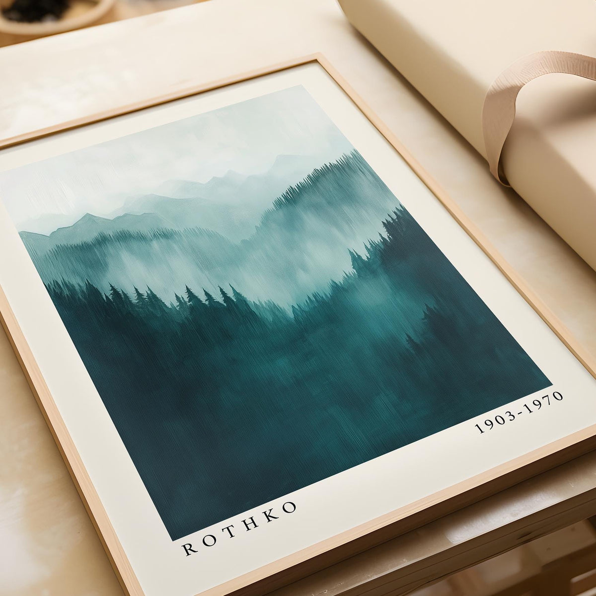 Framed Mountain Wall Art showing misty abstract mountain range in shades of blue and teal on a table