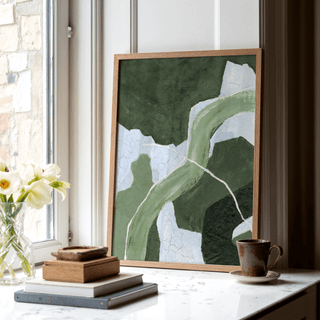 Abstract green art print of an abstract green flow leaning on a window sill with books and a cup nearby