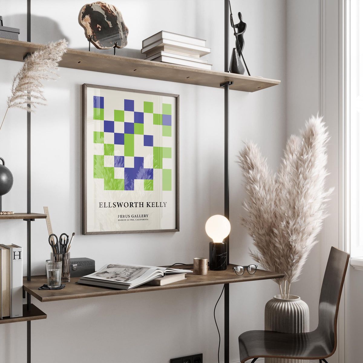 Minimal wall art of green and blue squares framed above a wooden desk with books and stationery