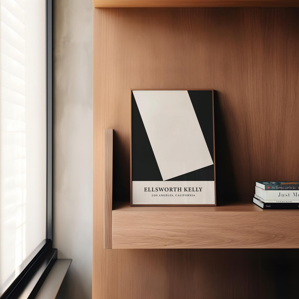Black and White Office Print leaning on a wooden shelf next to stacked books and window