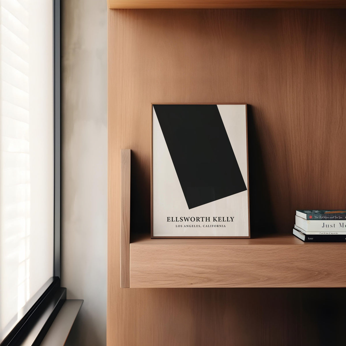 Black and White Office Wall Art leaning on wood shelf next to stacked books in brown office