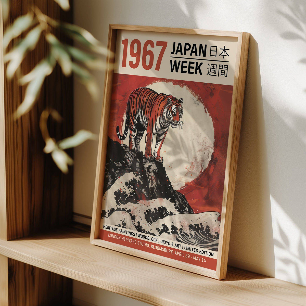 Print leaning on a shelf showing a tiger on rock with a red and white background and Japanese text