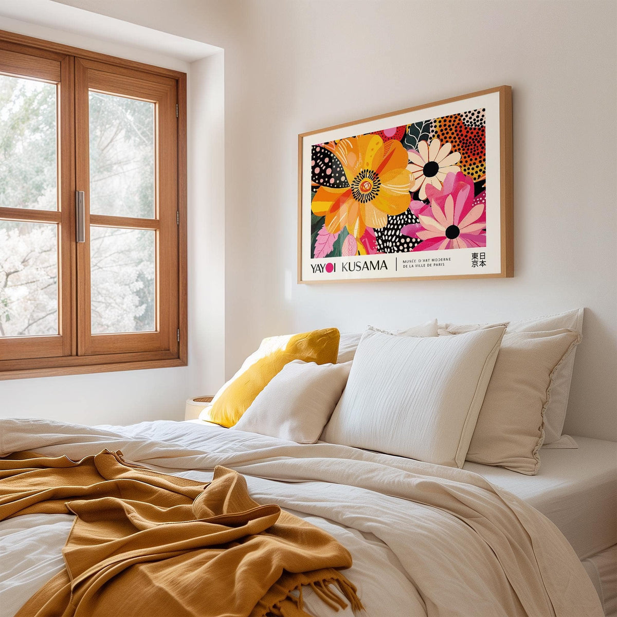 Floral Poster Art on a wall with bright orange and pink abstract flowers above a bed with white and yellow cushions