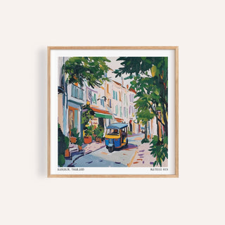 Holiday Prints wall art of a tuk-tuk in a street scene with green trees and pastel buildings