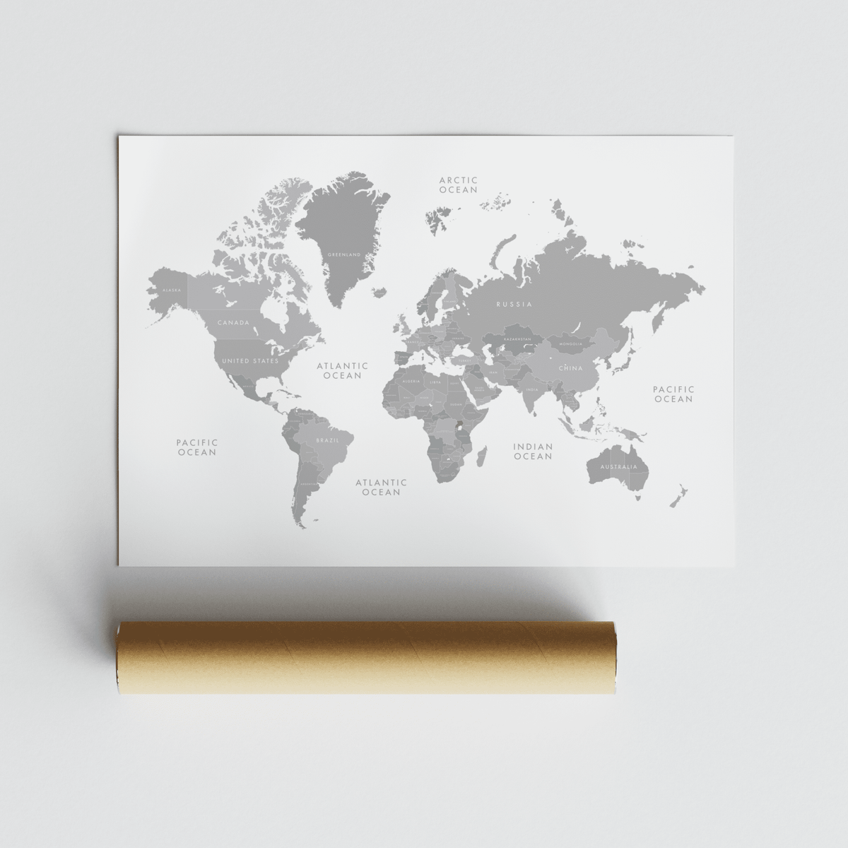 Minimalist world map art print showing grey continents and labels rolled with packaging tube