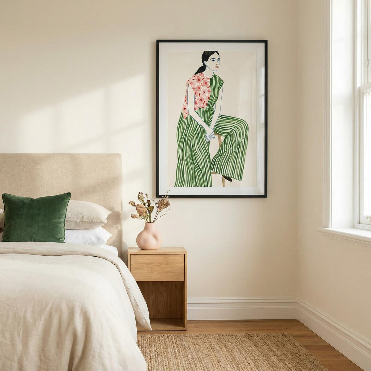Fashion Illustration Art Print framed on a bedroom wall above a wooden bedside table with a green cushion on the bed