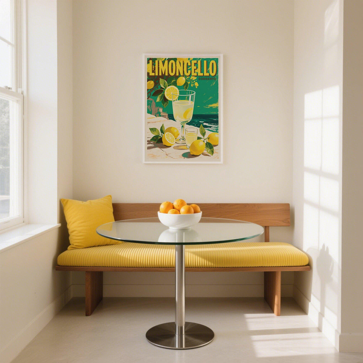 Drinks wall art of limoncello drink with lemons hangs above a yellow bench in a bright breakfast nook