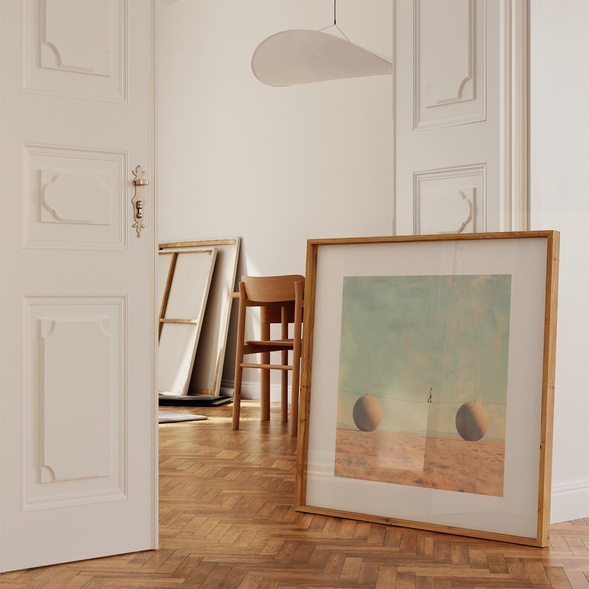 Print leaning on floor of surreal art for sale of a man walking tightrope between two spheres with muted colours