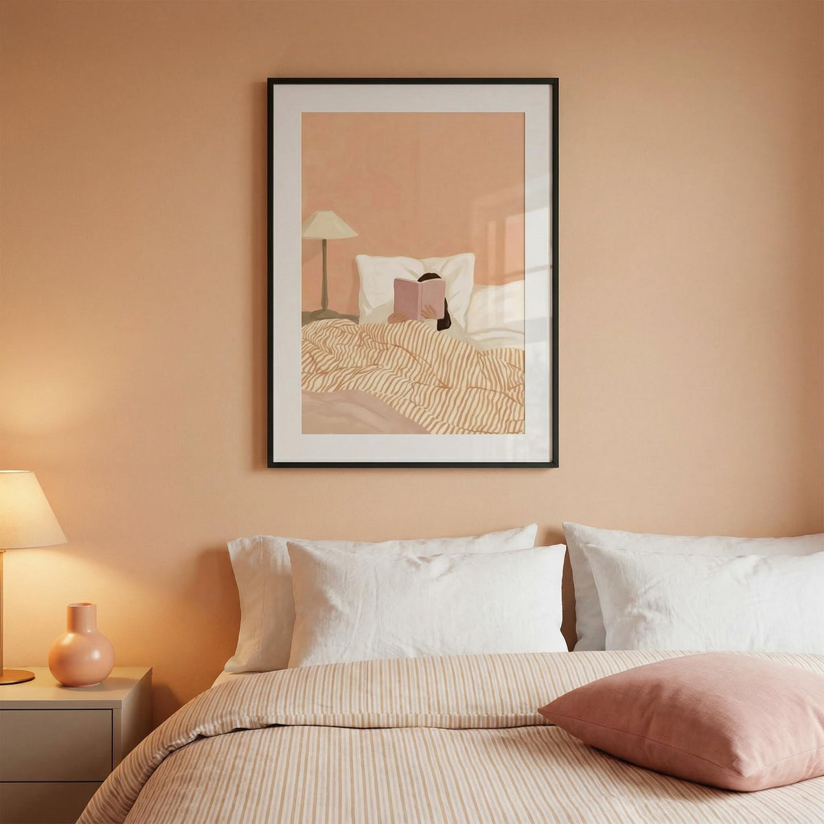 Woman Reading Book Art framed print in a bedroom with pink walls above a bed with white pillows and beige bedding