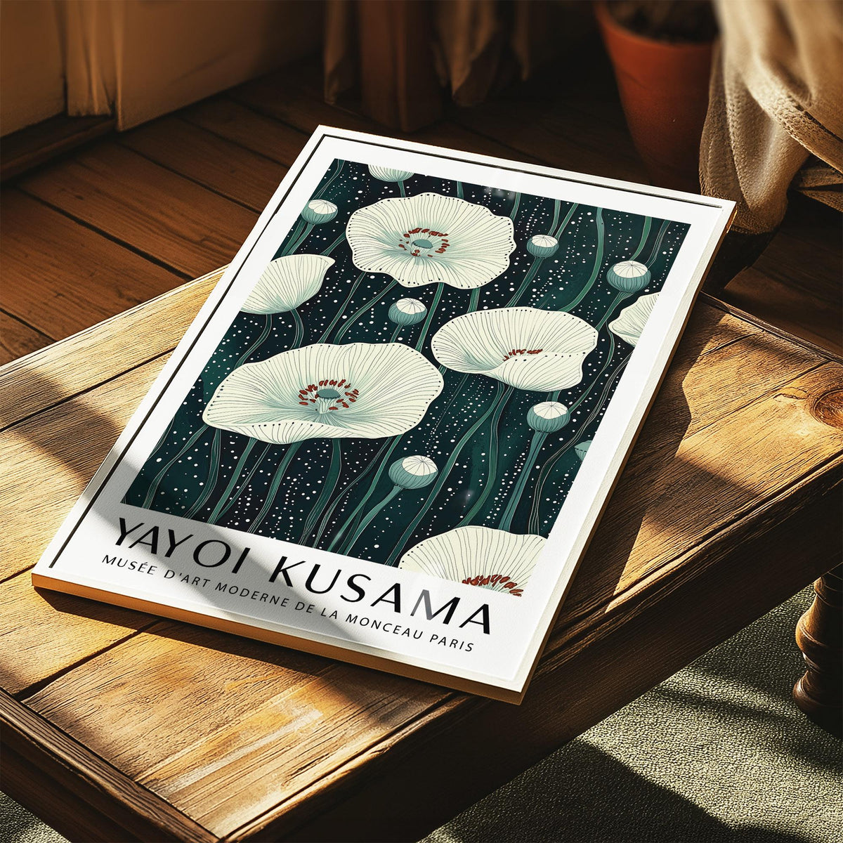 Poppy prints showing white poppies on a dark green botanical illustration style background lying on wooden surface