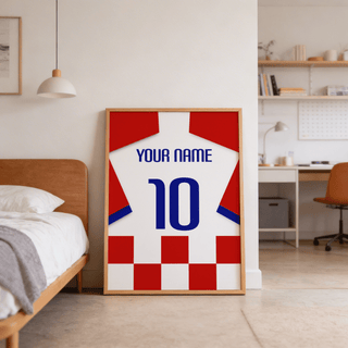 Football Shirt Poster in Red and White Checks leaning on the floor beside a wooden bed and desk in a bedroom