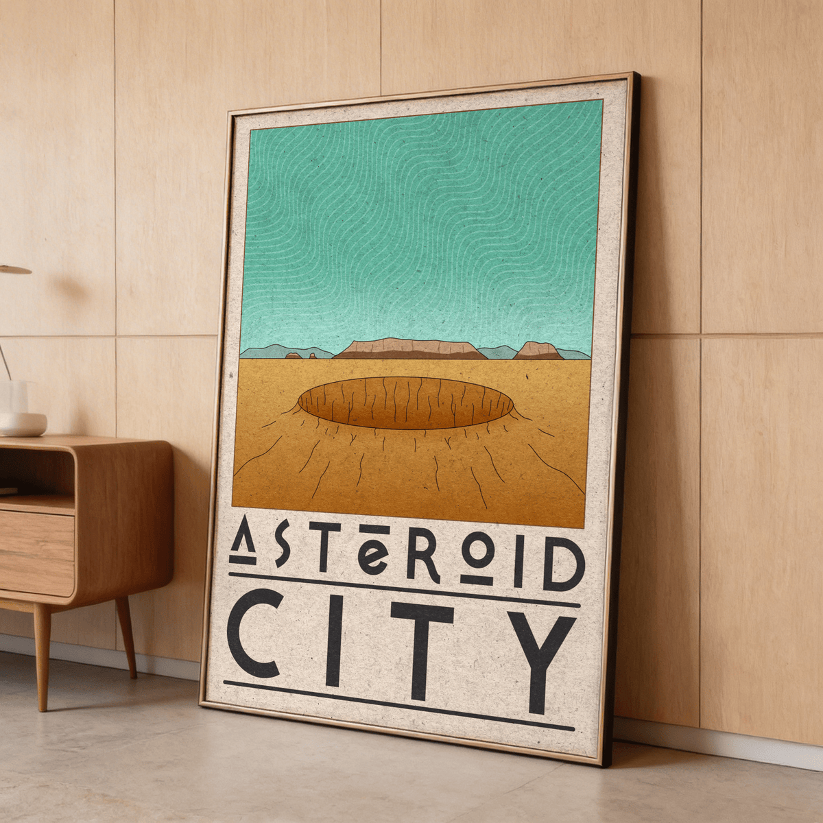 Framed Retro Desert Sci-Fi Poster with asteroid crater and minimalist illustration leaning against a wooden wall near a small shelf