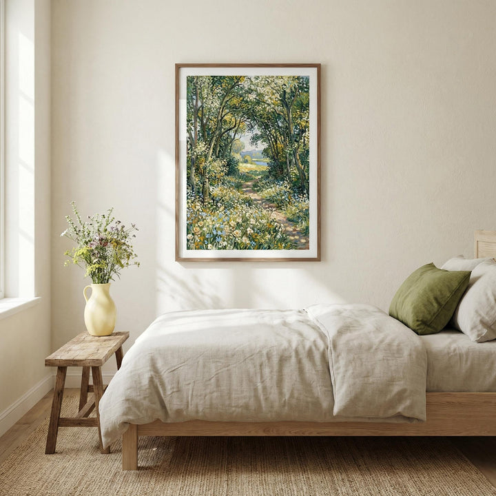 Impressionist art print of a woodland path with green and yellow foliage in a bedroom above a bed