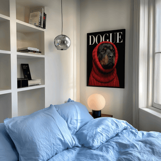 Rottweiler art print of a dog in a red sweater on a wall above a bedside lamp
