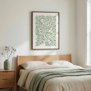 Green Leaf Art above a wooden bed with pale bedding and a green throw in a bedroom