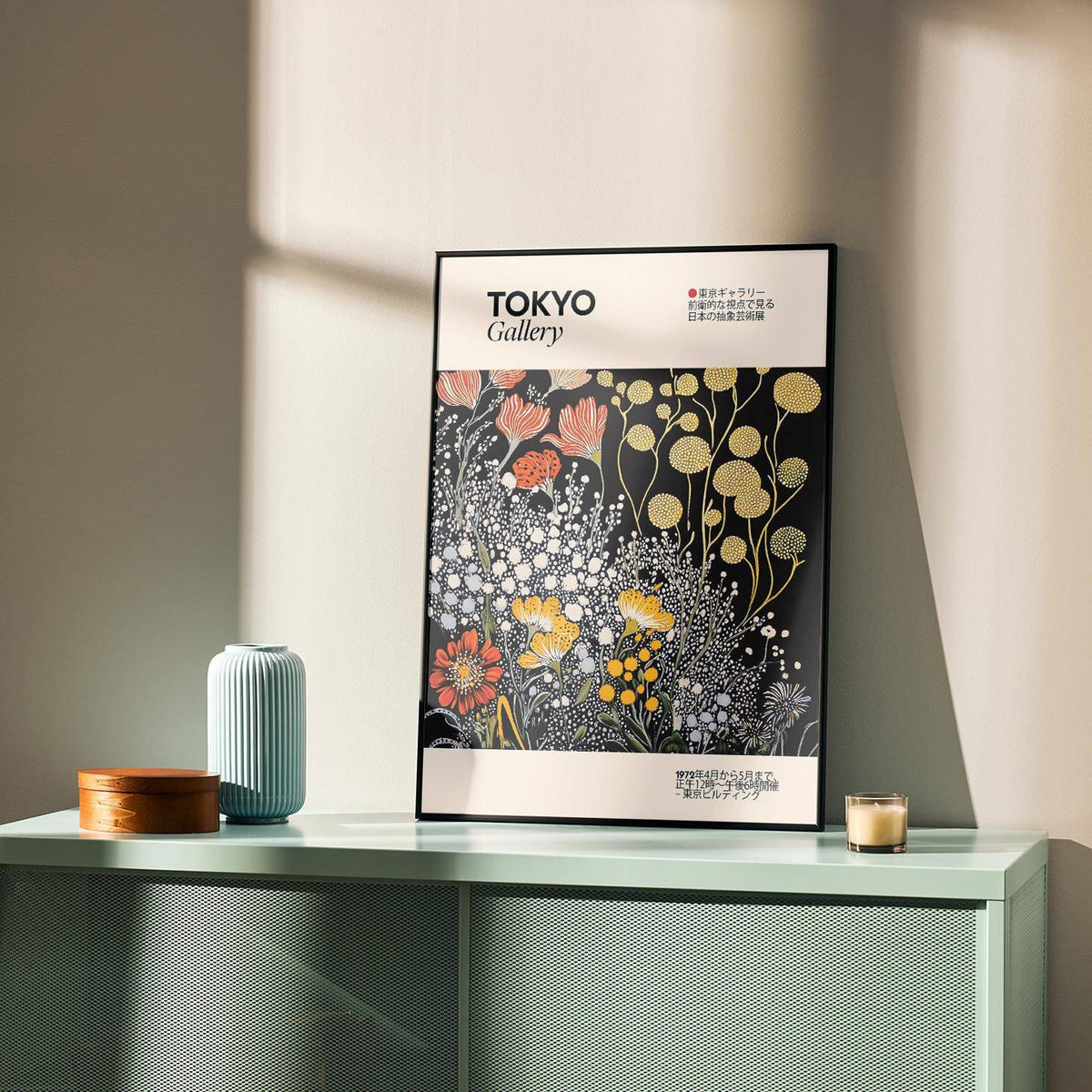 Print leaning on a shelf of vintage Japanese wall art with yellow and orange stylised flowers next to a blue vase