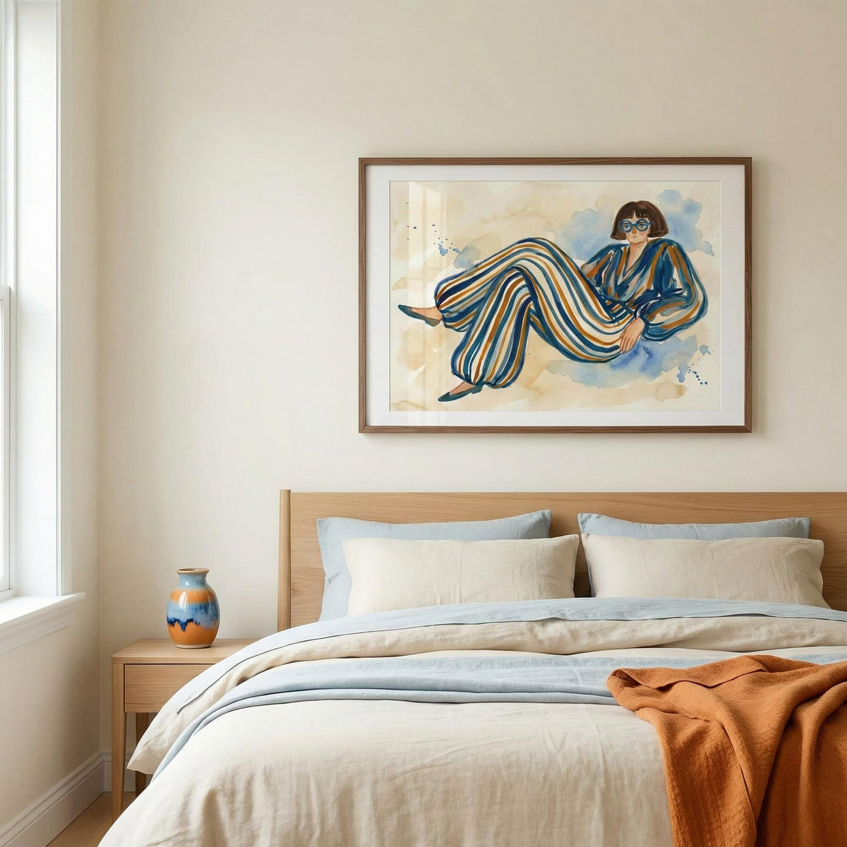 Modern Female Illustration framed print of a woman in a striped jumpsuit above a bed with blue and beige bedding