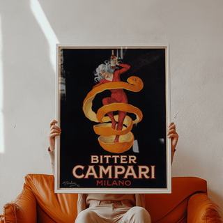 Framed Vintage Bitter Aperitif Poster held by person on an orange leather sofa with shadow on wall