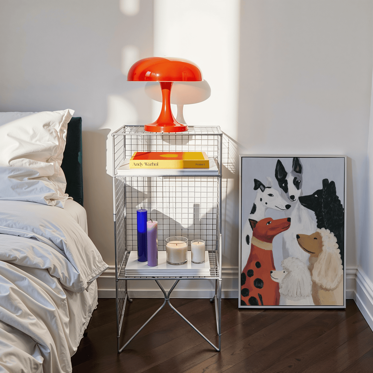 Colorful dog poster print leaning on floor beside bedside table with candles and a lamp