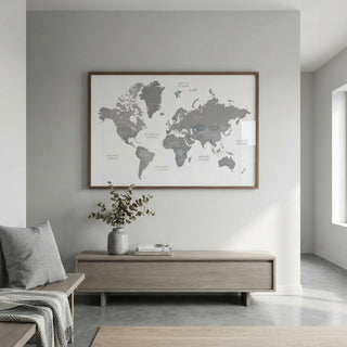World Map Art framed print on a grey wall with a vase on a cabinet below in a minimalist room