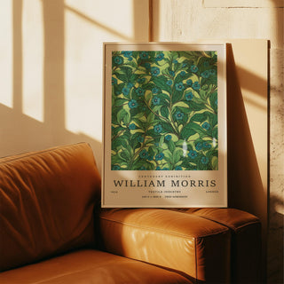 Framed Green Wall Art for Living Room with blue flower branches leaning on a leather sofa