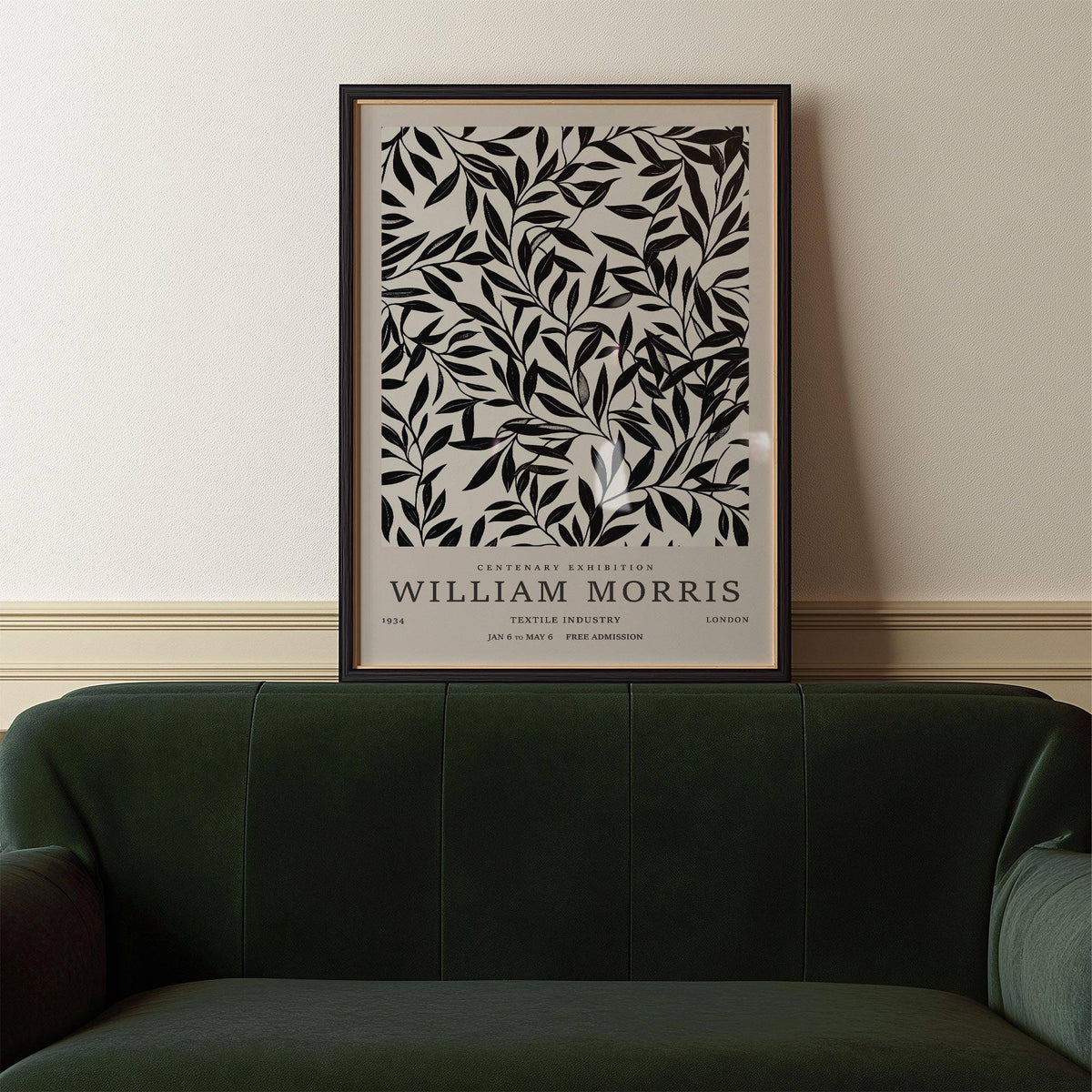 Black and White Vintage wall art of black leaf branches resting above a dark green sofa