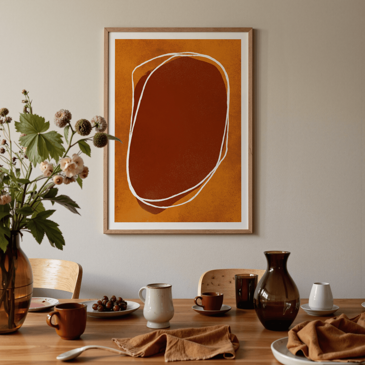 Abstract Earth Tone wall art with organic shapes in rust and burnt orange above a dining table with cups and a vase