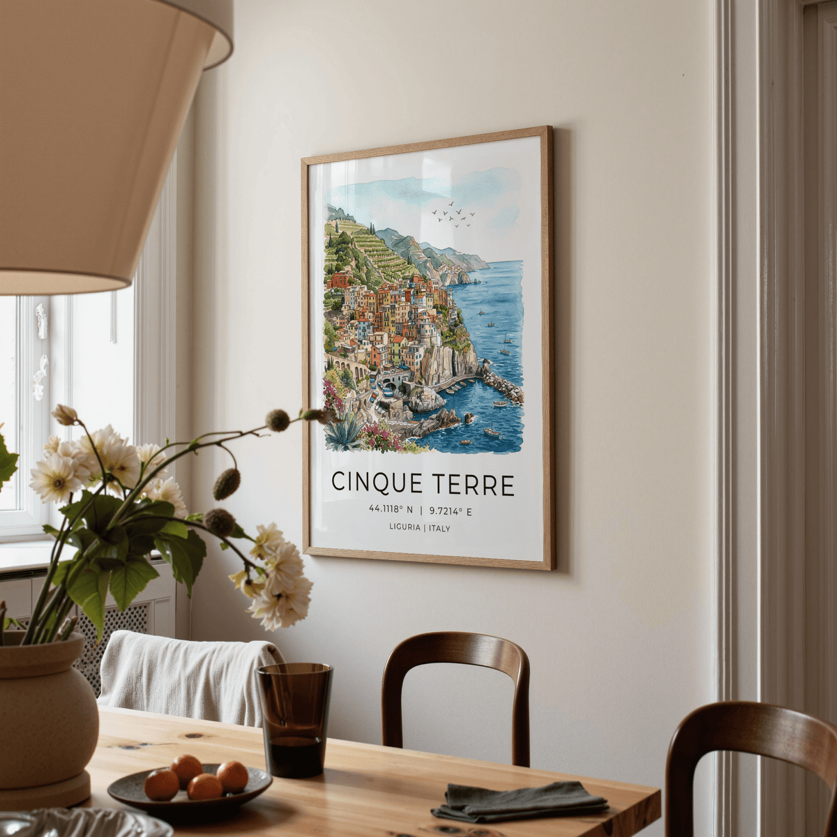Cinque Terre art print showing a colourful coastline watercolour hung on a dining room wall with a chair