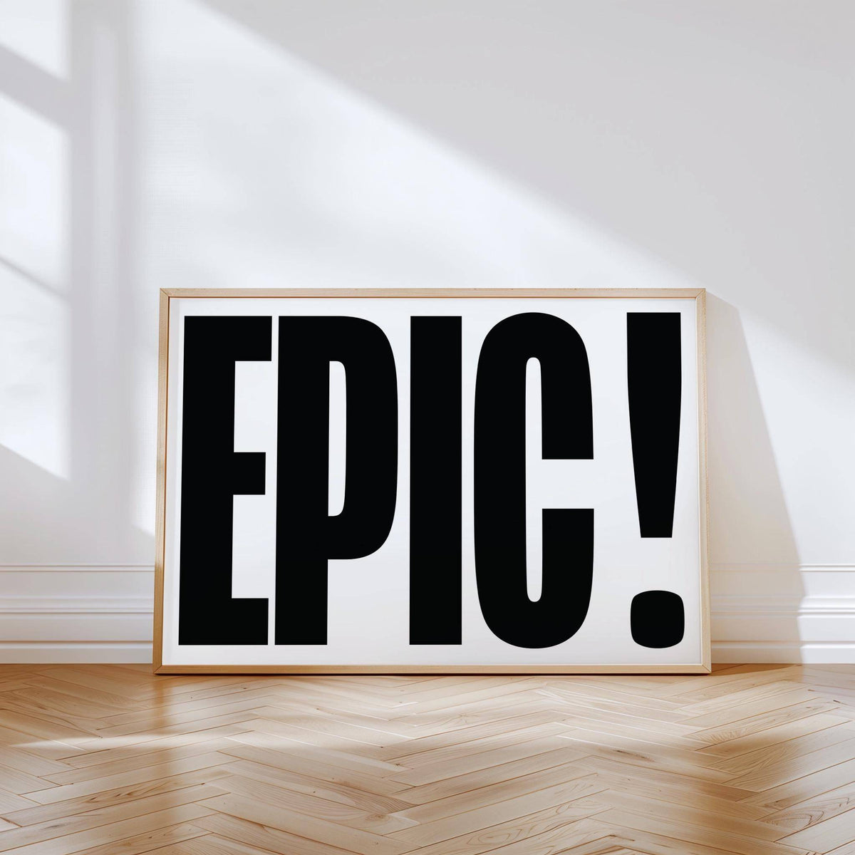Print leaning on a floor showing EPIC typography in black and white with natural light