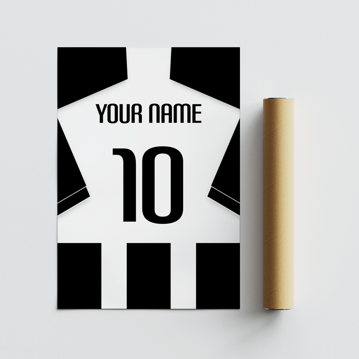 Football Shirt Poster in Black and White Stripes with Black Sleeves laid flat beside a brown packaging tube on a grey surface
