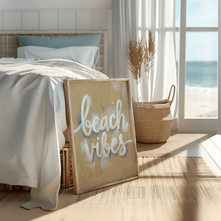 Beach Vibes wall art print leaning on a bed with cream linens and a rattan basket nearby