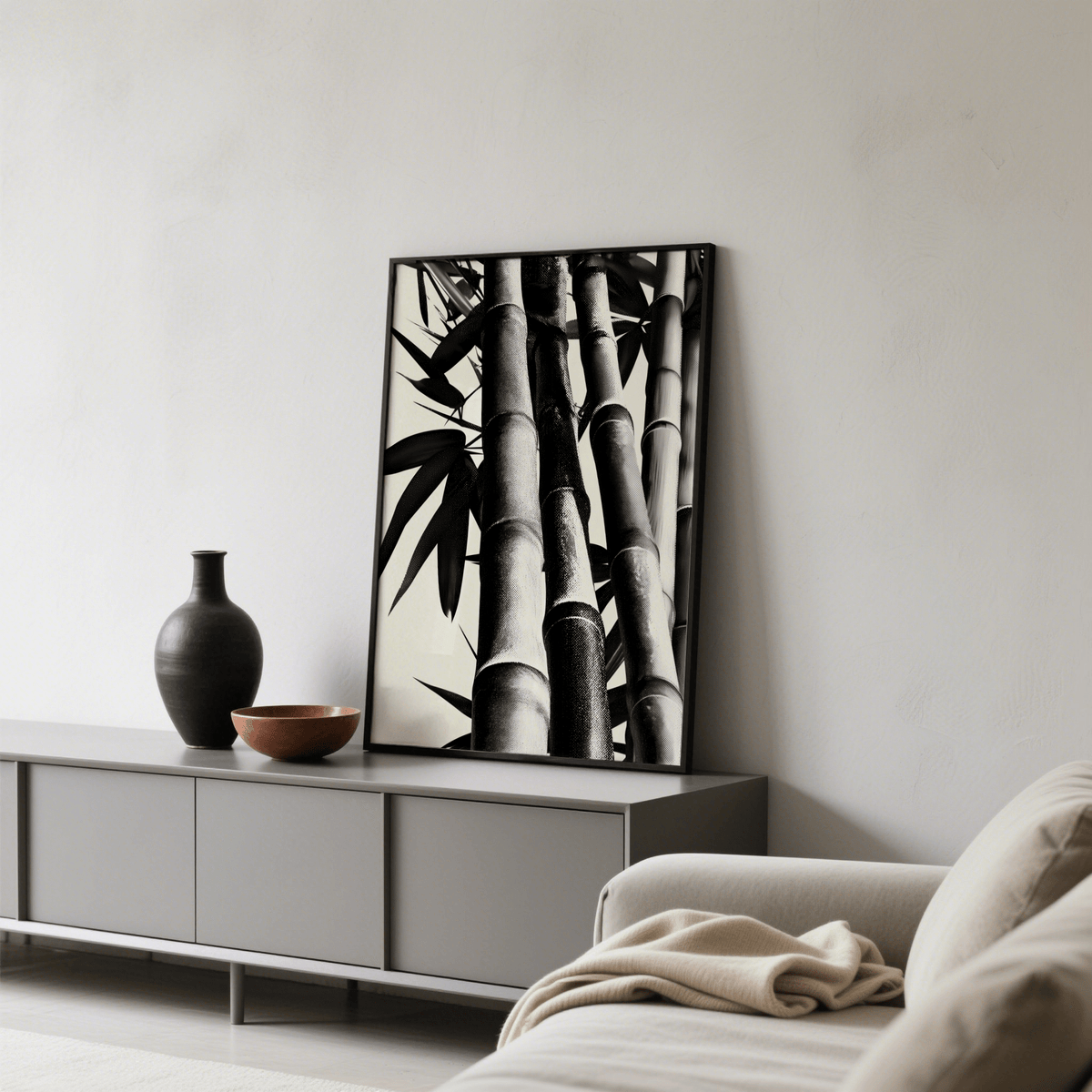 Print leaning on a sideboard with brown bowl and black vase neutral decor